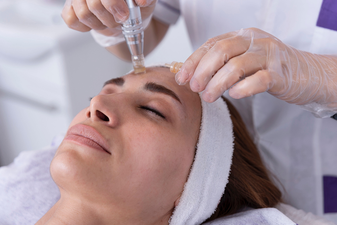 close up of Cosmetologist,beautician applying facial dermapen tr